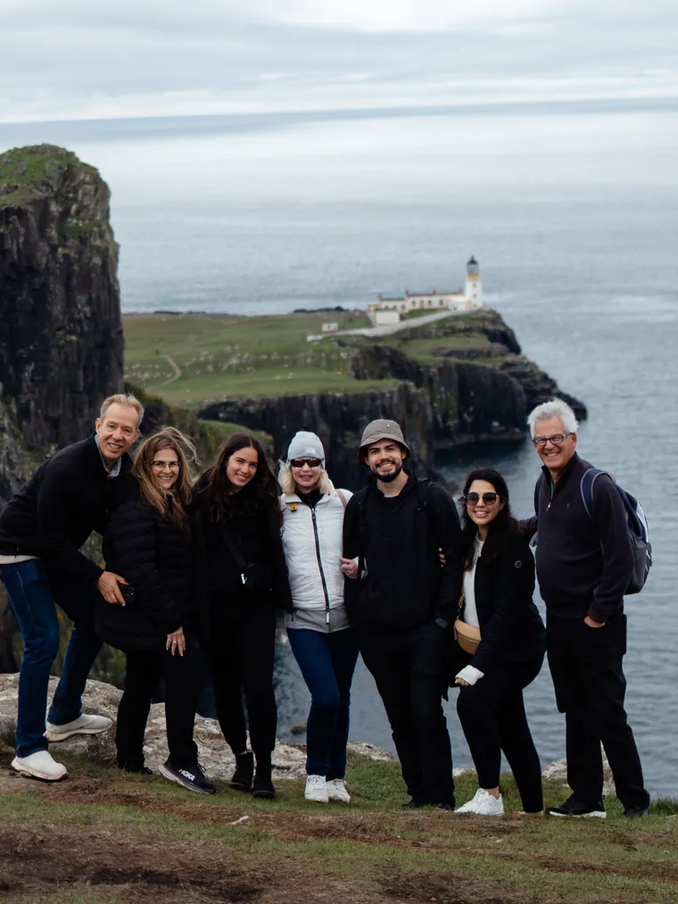 A travel group gathered on the cliffs above Neist Point lighthouse, Isle of Skye